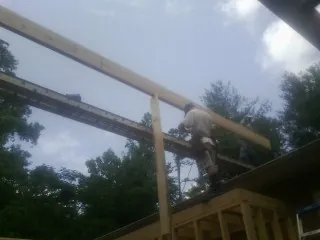 Carpenter setting a ridge beam over a new addition frame — Ice Dam Removal by Roofing Brothers in Nicoma Park
