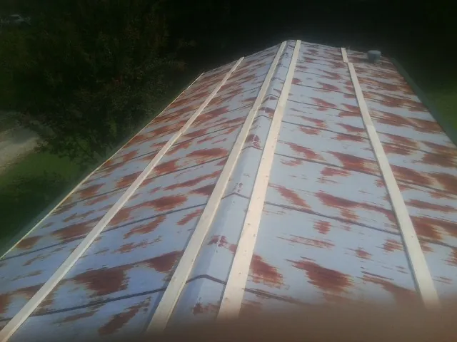 Rusted metal roof panels with new wood purlins before replacement — Storm Damage Roof Repair in Nicoma Park by Roofing Brothers