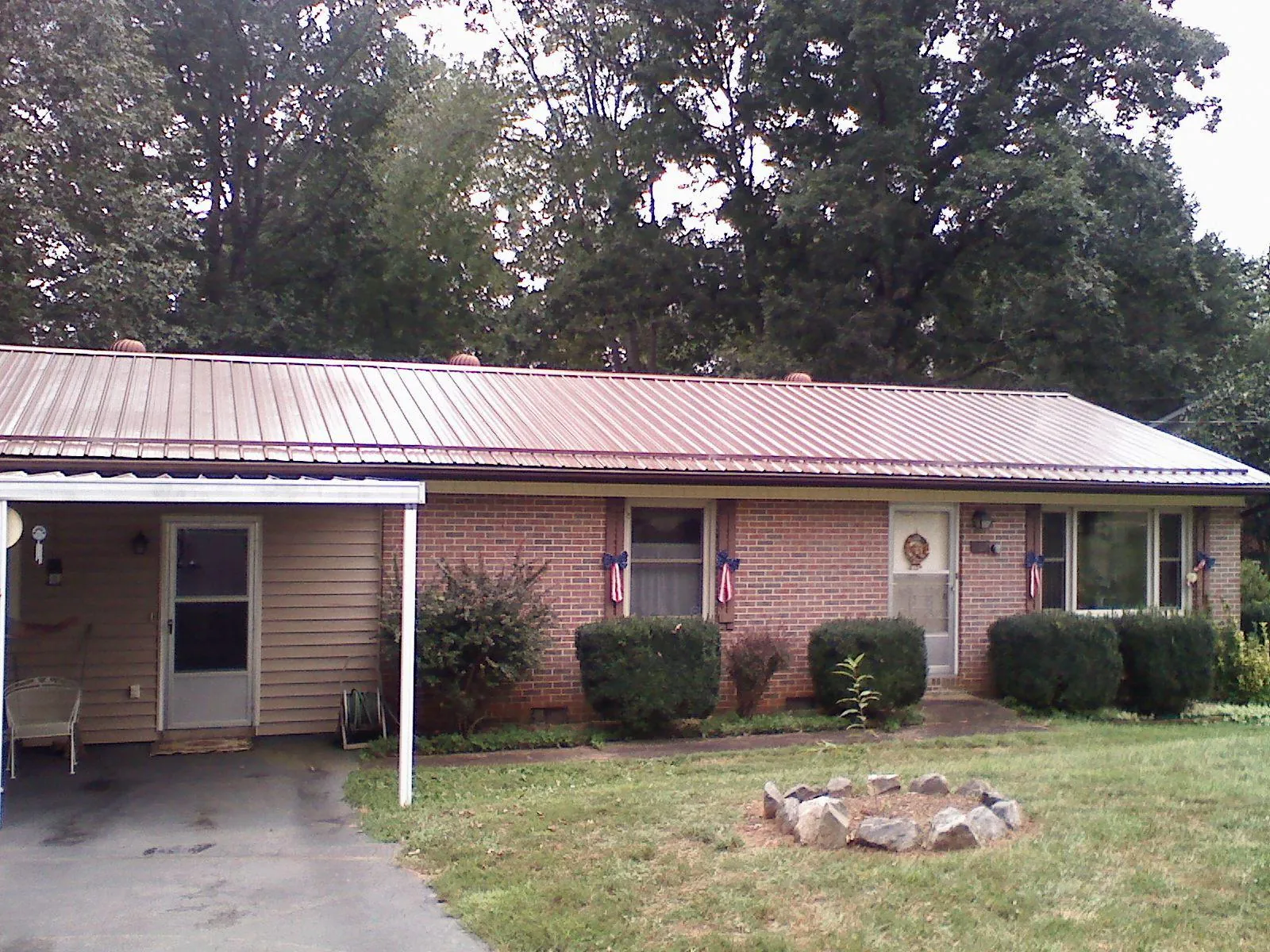 Bronze metal roof and carport on a brick ranch home — Roof Repair work by our crew in Nicoma Park
